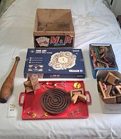 Full lot view showing the Zodiac Clock puzzle box, wooden toys on a red tray, two boxes of wooden puzzles, a wooden crate, and a wooden club-like object.