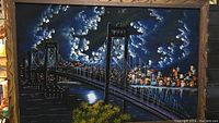 Front view of the framed vintage oil painting on felt showing a night scene with a large suspension bridge and illuminated city skyline beneath cloudy skies.