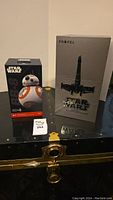 Photo showing both Star Wars drone and BB-8 droid boxes on black trunk