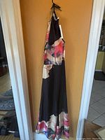 Long halter beach dress swim wrap with colorful abstract floral print and tags hanging on wall