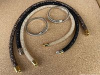 Photo showing all 5 Swarovski bracelets arranged on a cork-like surface: 3 wrap-around style bracelets with magnet closures in black, brown, and clear crystal tubing and 2 stretchy bangles with crystal ends.