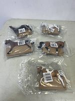Five Breyer horse figurines individually wrapped in sealed clear plastic.
