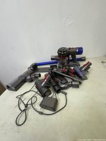 Image showing Dyson SV11 stick vacuum parts and accessories spread out on surface.