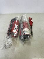 Two sealed Hilti items on a table including a fastener load cartridge and a tool insert bit in plastic packaging.