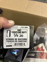 Close-up image showing box label for Paulin UNC Coupling Nuts 1/4-20 size.