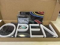 Photo showing neon light tubing formed into letters O, P, E, N, and accessories including LED pack and remote control