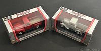 Two boxed die cast Ford pickup truck models side by side in collector edition packaging.