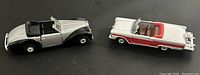 Both die cast cars shown from above, silver and black Talbot Lago and red and white Ford Fairlane convertible.