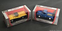 Both die cast truck models in original Collector's Edition boxes, yellow 1957 Ranchero and blue 1953 F-100 Pickup.