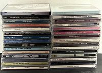 Photo showing front view of stacked jewel case CDs, various titles and artists visible