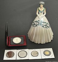 Overview of all items in lot including Queen Elizabeth II figurine and medals/coinst