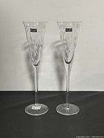 Pair of clear Stuart crystal champagne flutes side by side showing overall shape and design with label visible