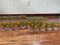 Full set of 12 Libbey Bonne Sante glasses showing the variety of sizes and the colorful Spice of Life vegetable and fruit design around each glass on the exterior.