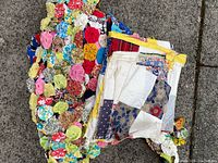 Photo of two retro quilt projects: colorful yoyo fabric quilt and scrap fabric quilt top on carpet.