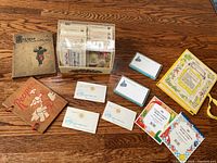 Photo of entire lot showing recipe book, plastic recipe file box filled with cards, McCalls recipe card box, loose cards and 1940s recipe card holder.