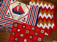 Three vintage crochet afghans: nautical sailboat, red granny square, and zigzag pattern