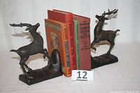 Front view photo showing the pair of brass leaping stag deer bookends with books between them for size demonstration.