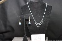 Photo showing the full set with necklace on stand and earrings on stand alongside.
