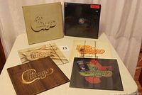 Six Chicago vinyl albums displayed on a table, showing their cover art and posters.