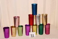 Twelve colored aluminum tumblers grouped, showing variety of metallic colors and different heights.