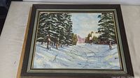 Full view of framed oil painting 'Winter Solitude' showing winter landscape with snow, pine trees, and cabins.