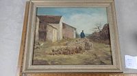 Full view of the framed oil painting showing shepherd walking with flock next to buildings on a dirt path.