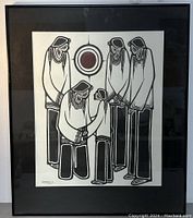 Full view of framed Native American art print showing five stylized figures and central circular motif, framed with black mat and thin black frame.