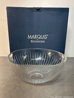 Clear glass fruit bowl with original blue Marquis by Waterford box behind it on a gray surface, showing full bowl and box branding