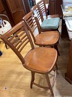 Three barstools angled view showing seat shape and back slats