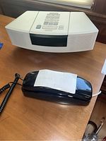Top view of Bose Wave Radio/CD and black AT&T phone with note on top of phone.