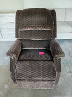 Front view of brown patterned fabric electric recliner chair, showing seat cushion and padded armrests.
