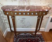 Full front view of the half-moon hall table showing wood details, marble top, and porcelain floral accents.