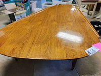 Front perspective of top surface showing kidney-shaped wood veneer tabletop with natural grain