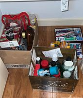 Photo of three boxes containing Remington shaver box, a hair dryer, and various grooming products including Gillette shaving gel and assorted bottles and tubes of creams.