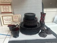 Photo of the full set showing plates stacked, candle holders, creamer, and sugar bowl with some original boxes.