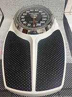 Top view of the weighing platform showing the black textured non-slip surface with white plastic base.