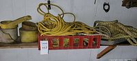 Overview photo showing various ropes and straps placed on a shelf and inside a red crate. Yellow, beige ropes and heavy-duty straps included.