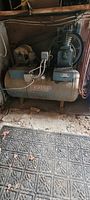 Overall view of Webster air compressor unit showing motor, tank, and exposed compressor pump with belt drive.