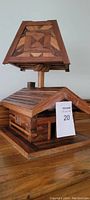 Wood birdhouse lamp showing angled front perspective, geometric patterned lampshade, and birdhouse base.