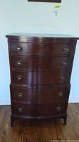 Front view of the highboy dresser showing all five curved front drawers with brass ring pulls