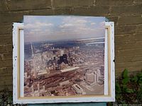 Aerial photo print of Toronto city skyline with visible CN Tower, rail yards, waterfront buildings, and airplanes flying overhead in smoke trails formation.