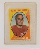 Photo of Frank Mahovlich sports card in protective sleeve showing front with yellow and orange background and player's portrait.