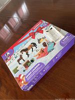 Photo of the closed boxed advent calendar showing the front festive holiday design with horses and included items