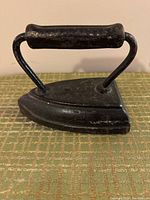 Front view of antique primitive flat iron showing handle and triangular base