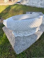 Side angle of concrete fish planter showing detailed scales and fins.