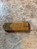 Vintage Lufkin #386 carpenter's folding rule closed on a surface, showing brass and boxwood materials with visible measurement markings