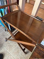 Top-view showing removable wooden serving tray with raised edges on wooden bar cart top tier.