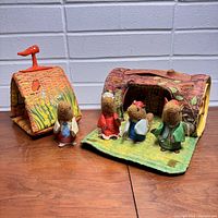 Playset showing three plush animal figures standing in front of two fabric houses