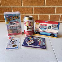 Front view of multiple Funko items including Fun2You soda can figure, Fun Run ice cream truck box, two sets of assorted pins.