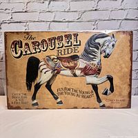 Full view of the vintage metal sign featuring a carousel horse and promotional text for a carousel ride.